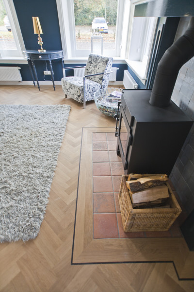 Visgraatvloer met band - open haard woonkamer - Vloerenbedrijf Bezema