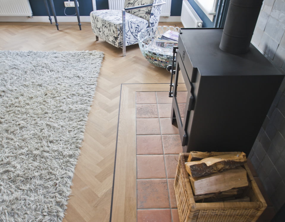 Visgraatvloer met band - open haard woonkamer - Vloerenbedrijf Bezema